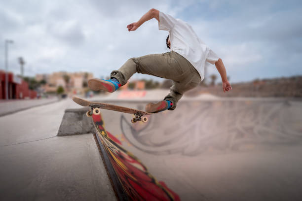 giovane skateboarder fa un trucco chiamato "fakie noseblunt" in uno skate park. - fakie foto e immagini stock