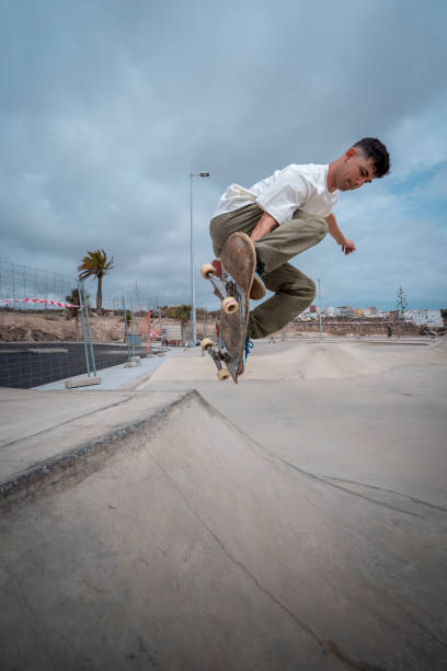 istock young skateboarder jumps over a ramp in a skate park. vertical composition 1409277300