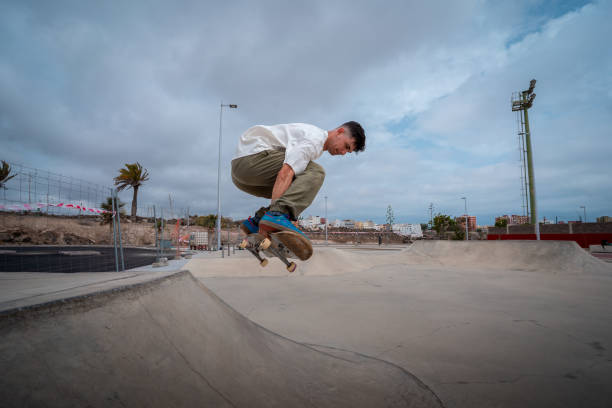 istock young skateboarder jumps over a ramp in a skate park. 1409277302