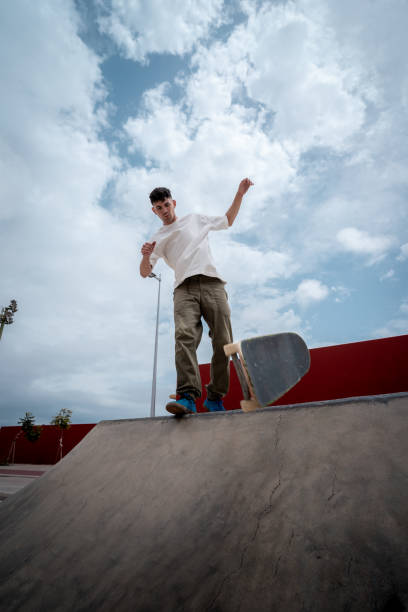 istock young male skater falls while attempting a trick on a skate park ramp. vertical composition 1409277322
