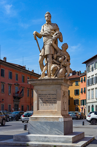 Pisa, Italy - May 23, 2022: Marble statue of Ferdinando I de Medici, Grand Duke of Tuscany in Carrara Square. In the sculptural composition next to the duke is a kneeling woman with two children.