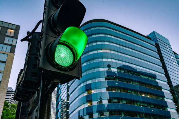 eine grüne ampel auf der straße im morgengrauen - green light stock-fotos und bilder