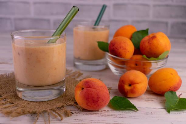 istock Apricot smoothie in glasses on a white wooden table. 1409279575