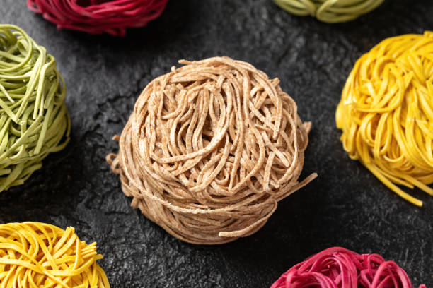 istock Dry whole wheat, beetroot, spinach and egg noodles on rustic dark background 1409280602