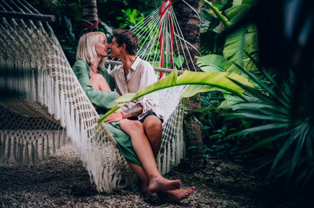 istock Couple having fun in hammock surrounded by tropical trees 1409283189