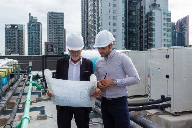 istock Engineer under checking the industry chilled water fan coil unit air conditioner is water cooling tower air chiller HVAC system of large industrial building to control air system 1409284169