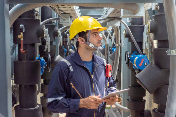 Engineer under checking the industry chilled water fan coil unit air conditioner is water cooling tower air chiller HVAC system of large industrial building to control air system