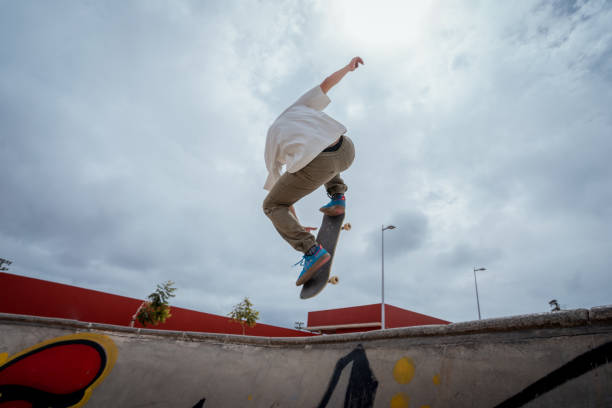 istock young skateboarder jumps over a bowl in a skate park 1409286691