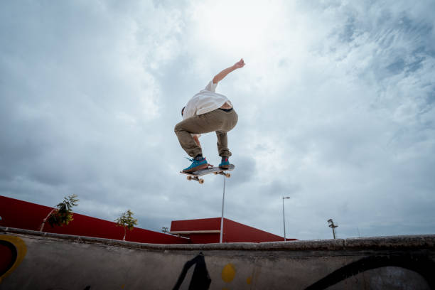 istock young skateboarder jumps over a bowl in a skate park 1409286698