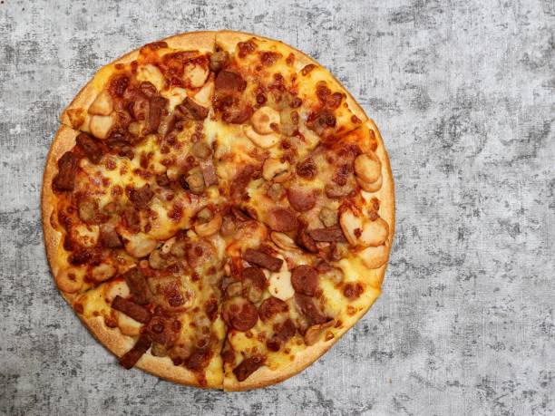 istock Pizza with mozzarella, sausage, mushroom, and beef topping on a grey background. 1409289909