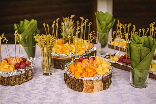 Fruit snacks on skewers on plate. Napkins. Autumn wedding ceremony. Party