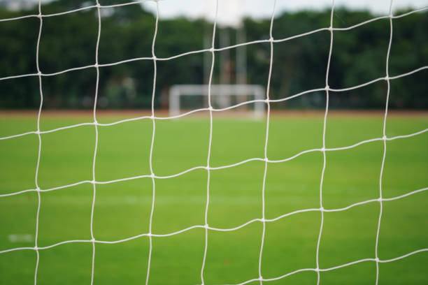 istock Football goal's net with stadium background. 1409293224
