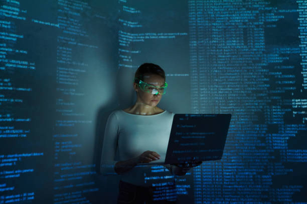 istock Confident woman in futuristic glasses using computer against dark background 1409294697