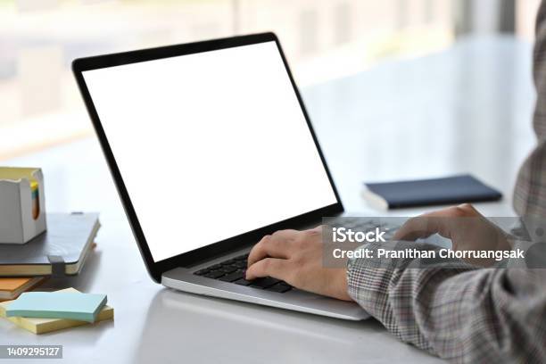 Close Up Side View Of An Adult Female In A Suit Typing Something With An Empty Monitor Screen Of A Laptop On A Busy White Desk Business And Technology Concepts Stock Photo - Download Image Now