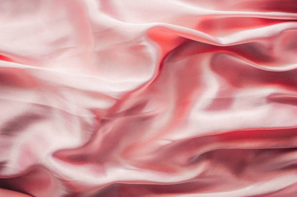 istock Smooth elegant pink silk or satin texture, abstract background luxury pink fabric with wavy folds 1409295248