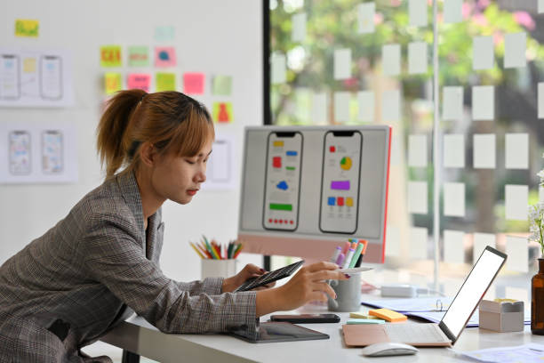 istock Side of Thai Asian female working on digital gadgets with her software development career. Technology and design concepts. 1409295903