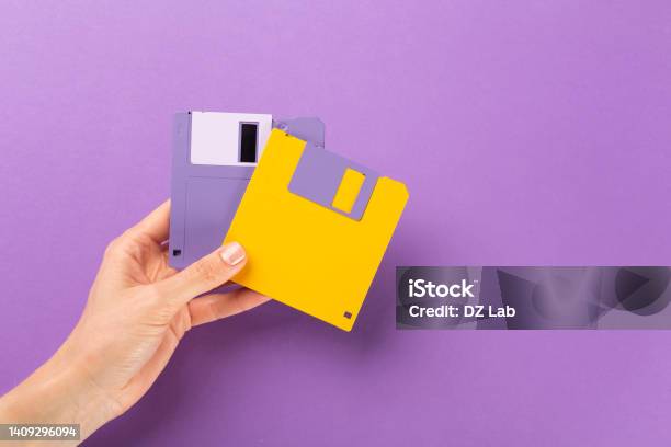 Hand Holding Floppy Disk On Color Background Technology Concept Stock Photo - Download Image Now