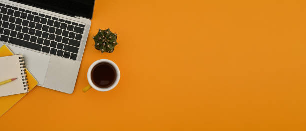 istock This is the top view position with a laptop computer, a cup of coffee, a cactus and office supplies on the left of a honey-yellow background. Flat lay composition. 1409296251