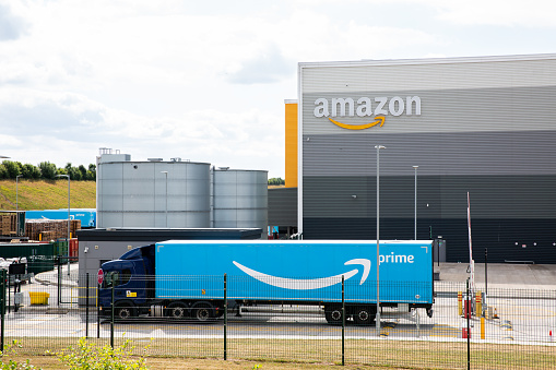 East Midlands Gateway, UK - July 15, 2022.  An Amazon Prime delivery truck arriving at a large Amazon warehouse fulfilment centre to oad with products