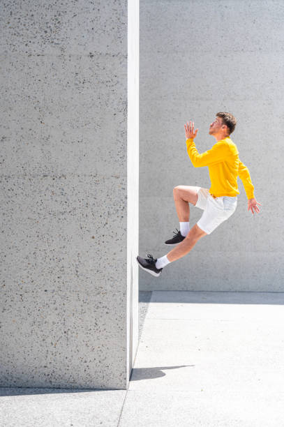 istock Young adult man jumping on the concrete wall 1409297721