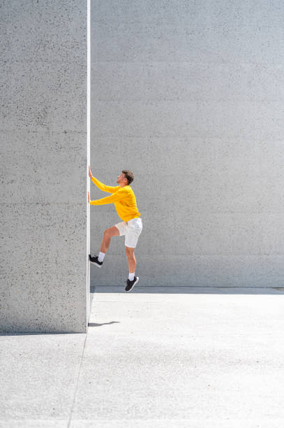 istock Young adult man jumping on the concrete wall 1409297762