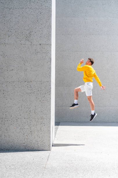 istock Young adult man jumping on the concrete wall 1409297773