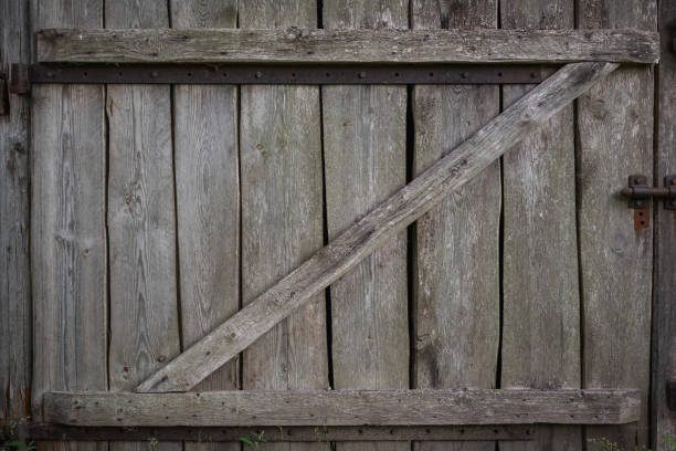 istock Old gate made of weathered boards in a rustic barn. Retro background in eco style. 1409298225