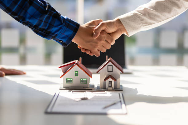 los agentes inmobiliarios se dan la mano después de que se complete la firma del acuerdo contractual. - inmobiliaria fotografías e imágenes de stock