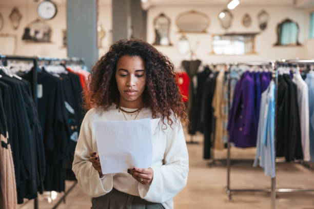 femme au travail dans un immense grand magasin de vêtements - boutique store owner latin american and hispanic ethnicity photos et images de collection