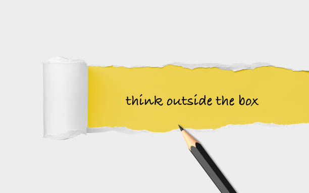 istock Think Outside The Box Written on a Torn Yellow Paper with a Black Pencil 1409300451