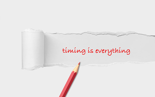 Timing is Everything title is written on a torn white paper with a red pencil sitting on it. Easy to crop for all your design and print needs.