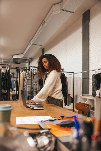 femme au travail dans un immense grand magasin de vêtements - boutique store owner latin american and hispanic ethnicity photos et images de collection