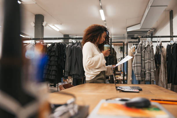 femme au travail dans un immense grand magasin de vêtements - boutique store owner latin american and hispanic ethnicity photos et images de collection