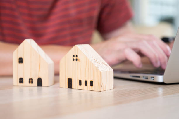 istock Selective focus at wooden house model with calculator and paper note on wood table. Saving plan and interest rate to buy property, house. Personal financial concept for own a house. 1409301735