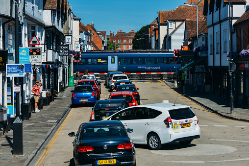 Canterbury, UK - July 16, 2022: High speed train passing a rail crossing on Wincheap in Canterbury, Kent, UK