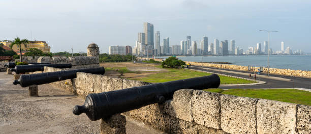 Cannons on old fort wall with Cartagena skyline in background stock photo