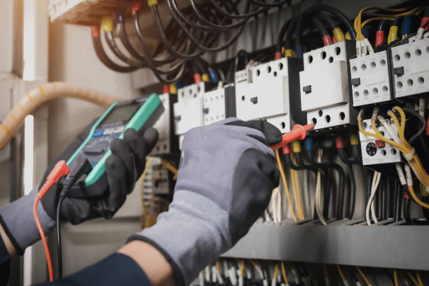istock Electricity and electrical maintenance service, Engineer hand holding AC multimeter checking electric current voltage at circuit breaker terminal and cable wiring main power distribution board. 1409304335