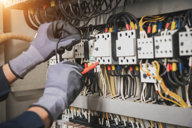istock Electricity and electrical maintenance service, Engineer hand holding AC multimeter checking electric current voltage at circuit breaker terminal and cable wiring main power distribution board. 1409304336