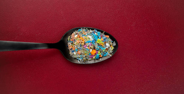 Close-up top shot on micro plastic particles in a spoon. Concept for water pollution and global warming. stock photo