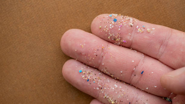 istock Micro plastic particles on a human finger for scale. Concept for water pollution and global warming. 1409308593