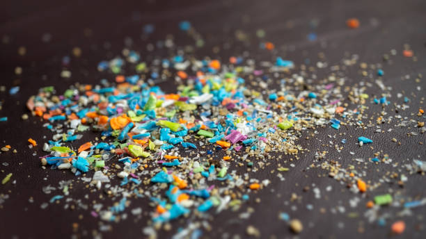 istock Close-up on micro plastic particles against dark background with copy space on the right. 1409308615