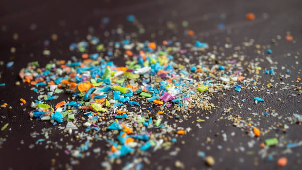 Close-up on micro plastic particles against dark background with copy space on the right. stock photo