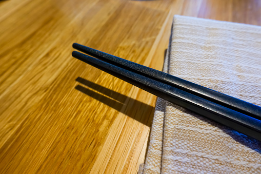 Asian cuisine concept with chopsticks placed on a table in a Korean restaurant with natural and contemporary interior design
