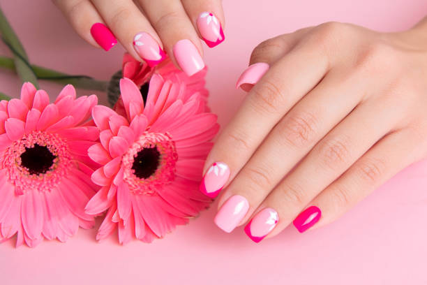 Female hands with pink manicure, flowers design