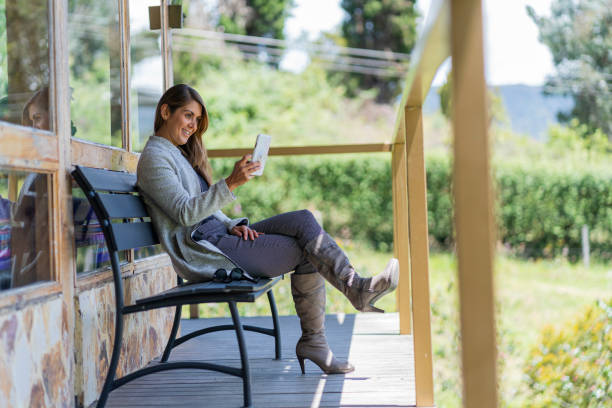istock Beautiful woman sitting using her cell phone to make a video call from her hotel complex 1409316268