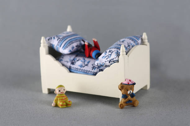 dollhouse interior - toy bed and toys isolated on gray background. Image contains copy space