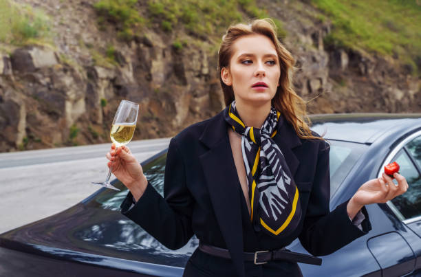 ワインをグラスにかけた女性が、冷静な運転手を待っている。指定ドライバーサービス - designated driver ストックフォトと画像