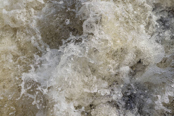 istock Water bubbles and splashes in a heavy stream at the waterfall in closeup. 1409321152