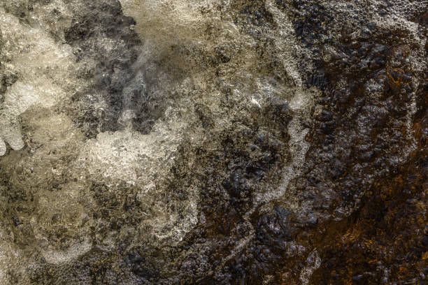 istock Water bubbles and splashes in a heavy stream at the waterfall in closeup. 1409321153