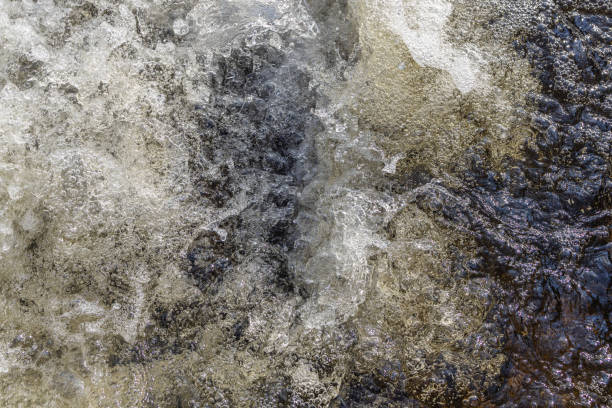 istock Water bubbles and splashes in a heavy stream at the waterfall in closeup. 1409321154